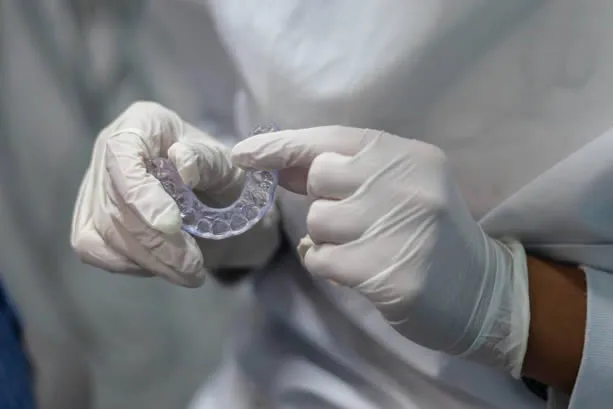 Dental technician holding custom night guard appliance