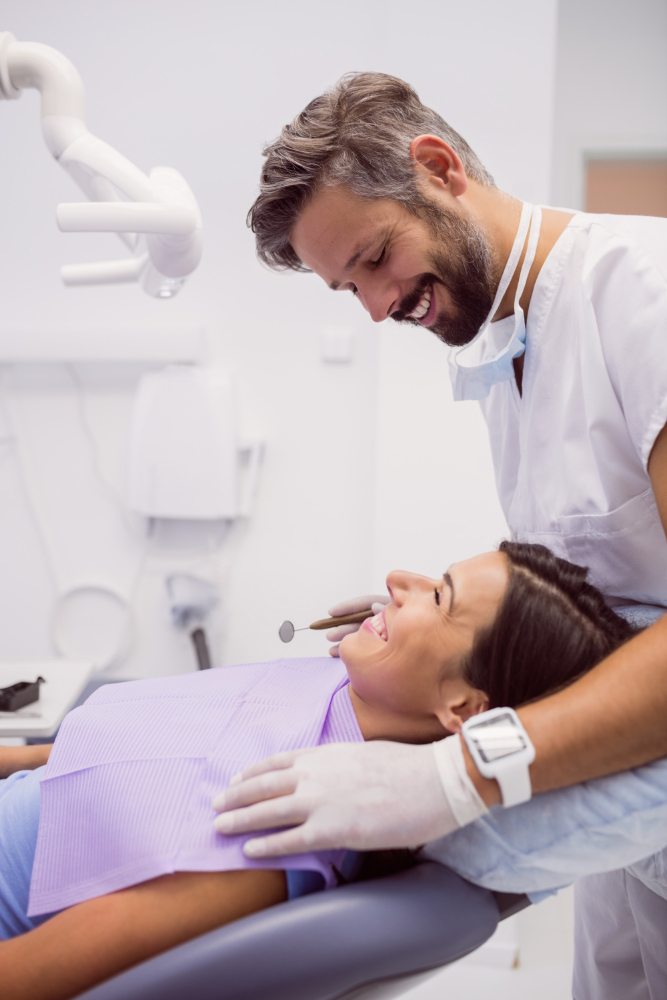 Dentist examining patient during dental cleaning visit