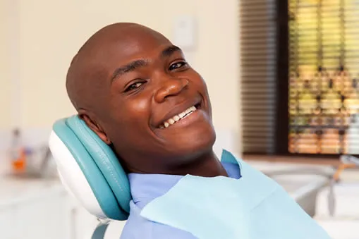 Happy man smiling in dental chair at Roam Dental Shelby Township