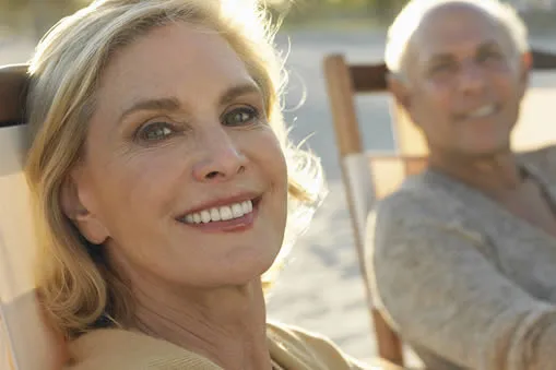 Middle-aged woman smiling after full mouth restoration at Roam Dental