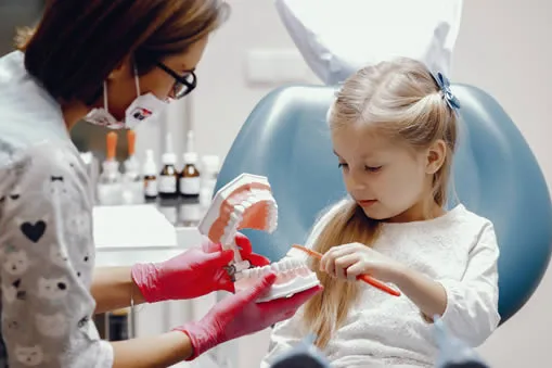 Young child brushing teeth at dentist office